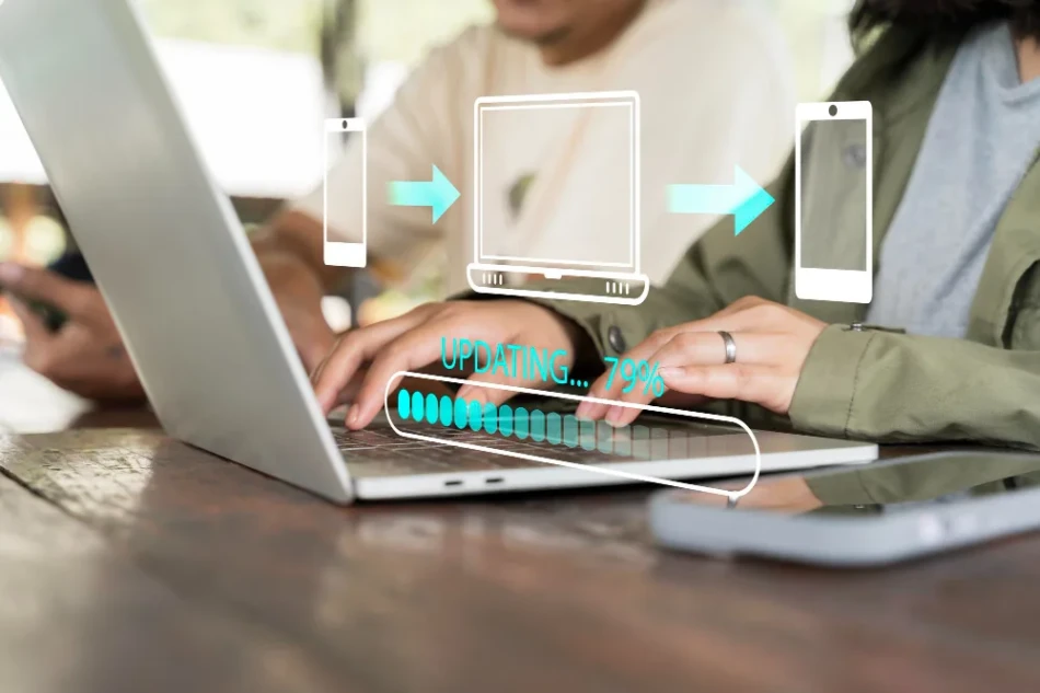 Pessoa digitando em notebook com icones de dispositivos e barra de progresso de atualizacao representando o processo de migrar plataforma